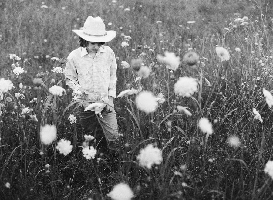 Dallas film photographer photographs cowboy in wild flower field. 