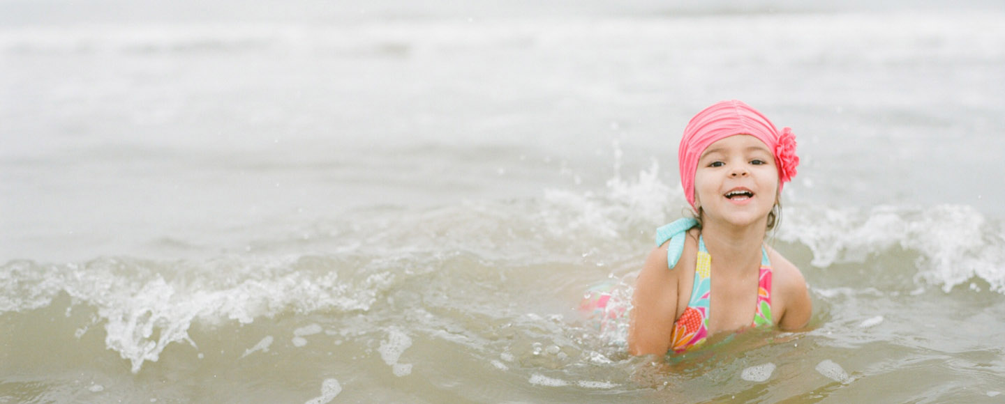 Little girl wearing old style swim cap captured by Dallas film photographer, in Galveston.